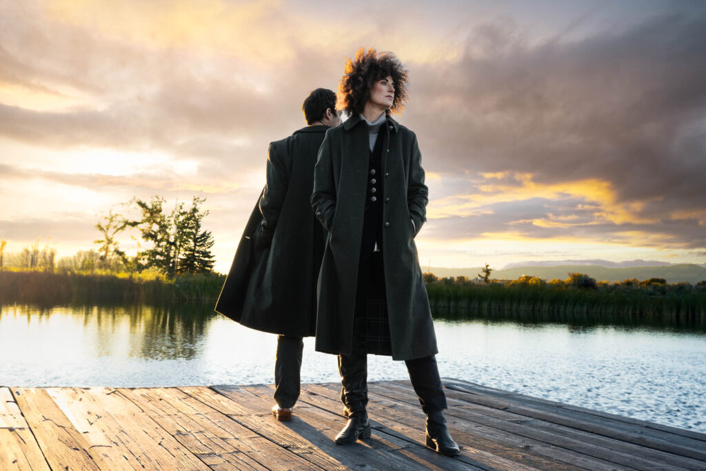 couple on dock wearing Loden Coats by the water in the mountains