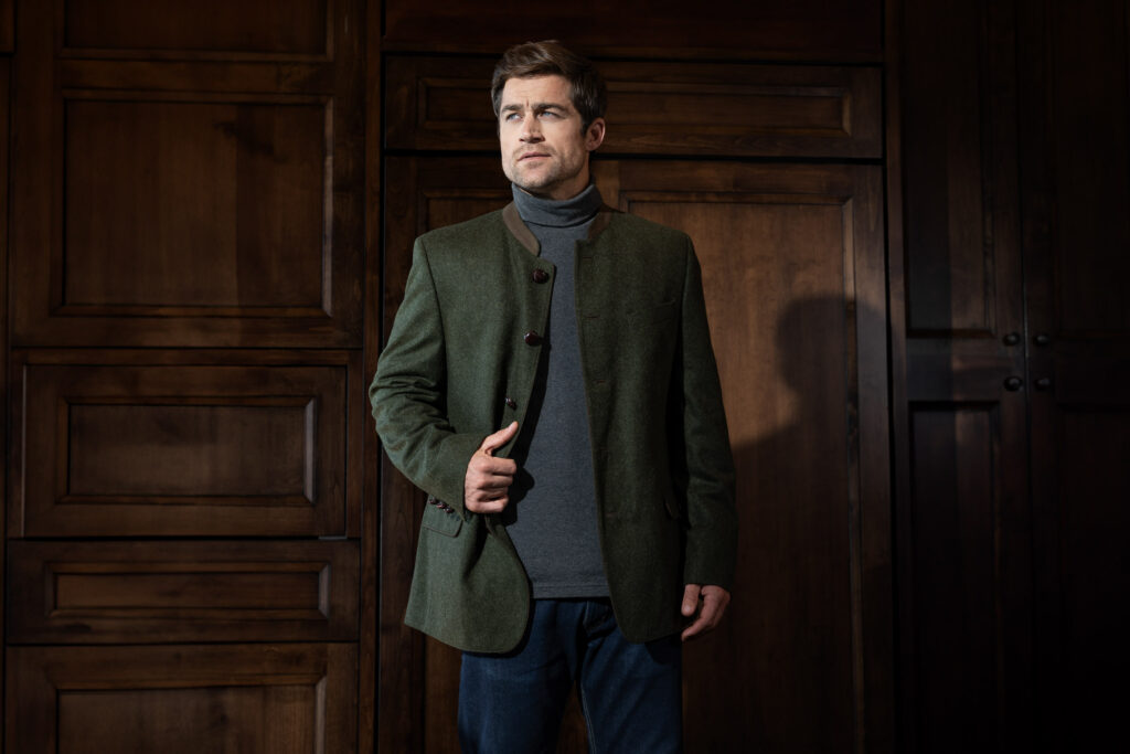 Handsome man in a large house wearing the Loden Alpine Blazer 'Edward' in green by Robert W. Stolz